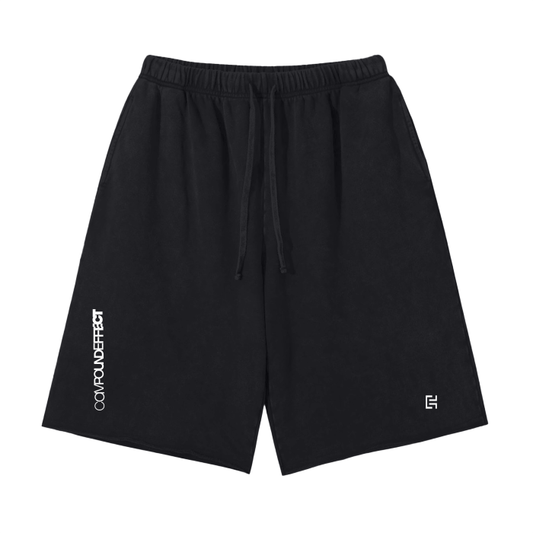 These Scattered Edge Vintage Washed Short Pants by ODMPOD are crafted from 100% cotton, featuring the text "CONCOMPOUND EFFECT" vertically on the left leg and a small geometric logo near the bottom right hem. Designed in a regular fit, they include a drawstring waistband for ultimate comfort in men's street casual clothing.