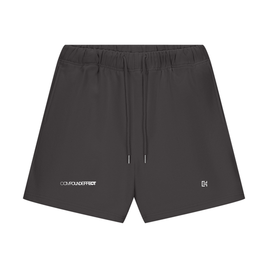 The Streetwear Unisex Heavyweight 460G Fleece Loose Fit Shorts by ODMPOD are crafted from soft cotton and feature an elastic waistband with drawstrings. These dark gray shorts display small logos on the lower front legs, making them perfect for versatile everyday wear.