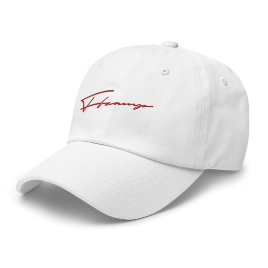 The HT004 hat by C3 is a white baseball cap featuring a red, stylized signature embroidered on the front. The signature boasts a dynamic, flowing design. This low-profile dad hat also includes a curved brim and an adjustable strap at the back. The background is black.