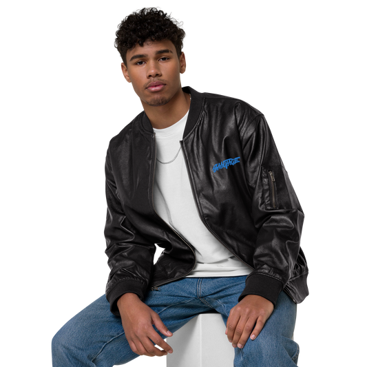 A person wearing a C3 UJ002 ▪ Bomber Jacket in black PU leather over a white shirt, paired with blue jeans. They are seated and looking at the camera with a neutral expression. The background is plain black, making the person and their classic piece outfit stand out.