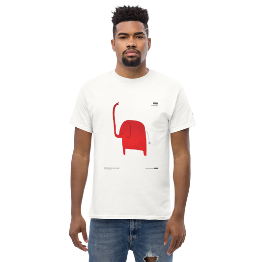 A person with short hair and a beard is wearing a white UT050 ▪ T-Shirt by C3 featuring a simple red cartoon elephant illustration. The individual is posing against a black background and is also wearing light blue ripped jeans.